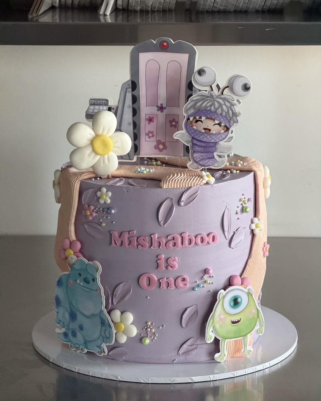 Monsters Inc Themed Novelty Cake - Sulley Mike and Boo on lavender buttercream with fondant daisies Brisbane